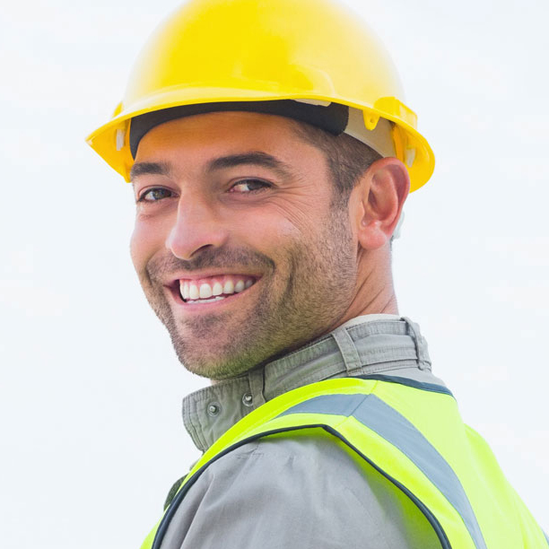 headshot of construction worker smiling while wearing a yellow safety vest and hard hat