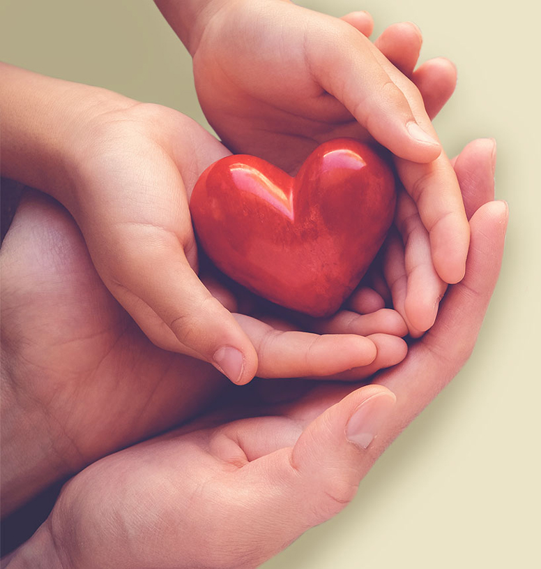 adult and young child holding a heart shaped object together