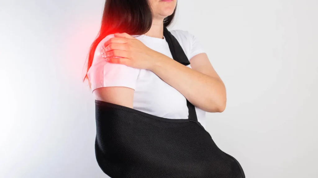 Woman in a sling with highlighted shoulder pain after injury.