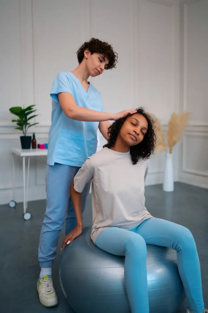 Female patient receiving physical therapy using a stability ball for posture and spinal alignment correction.