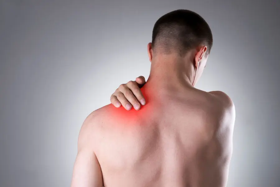 Man with red glow on upper back and neck, showing muscle tension.