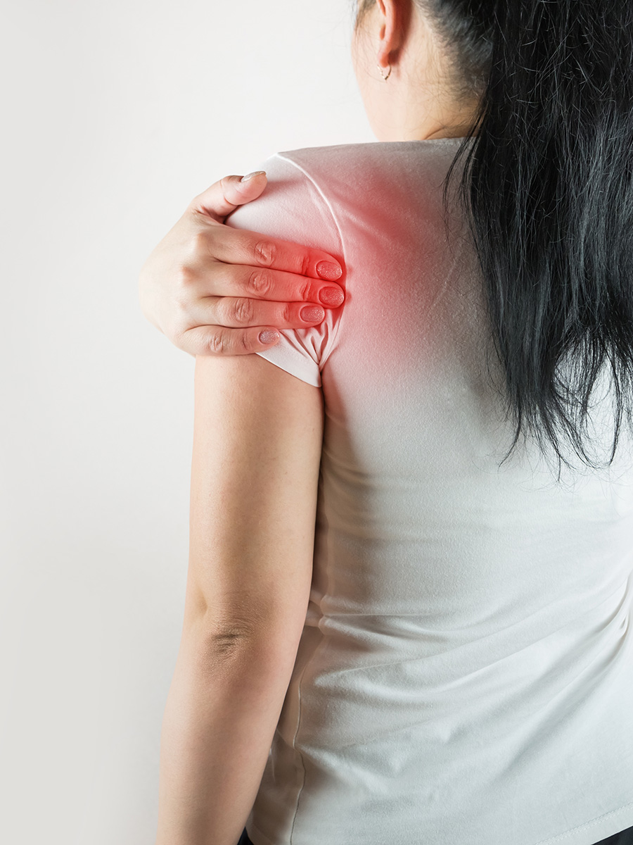 Woman holding her shoulder in pain