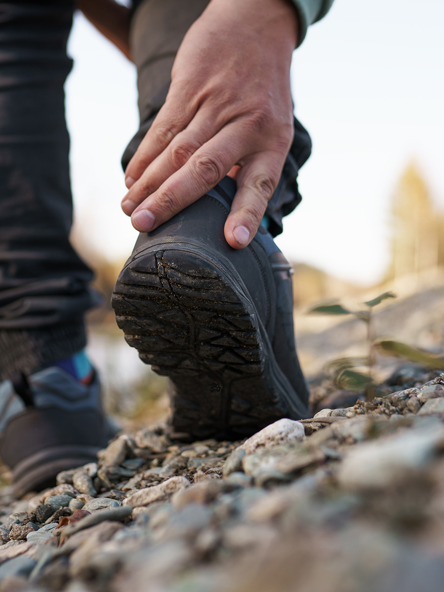 A man holding his leg during a hike
