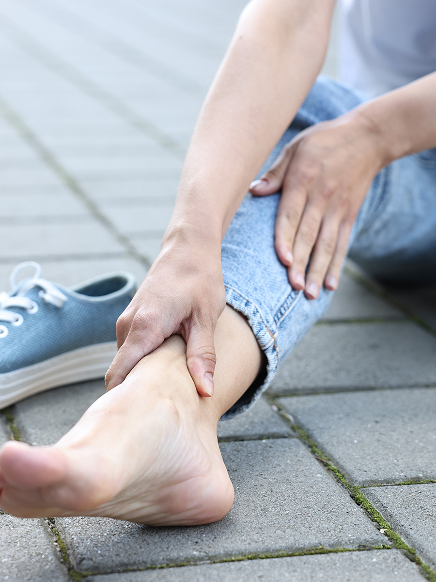 A woman holding her ankle in pain
