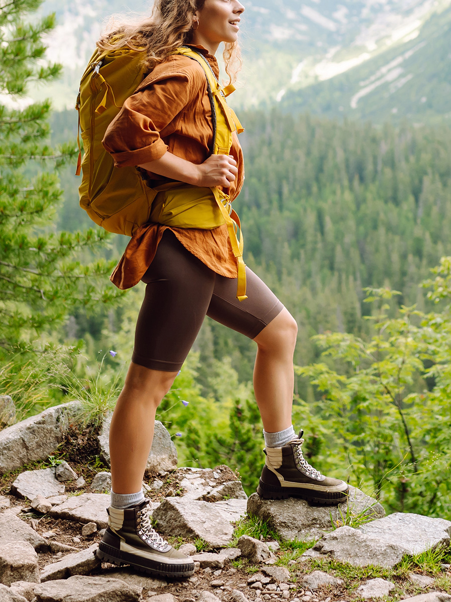 A woman in orange hiking outdoors