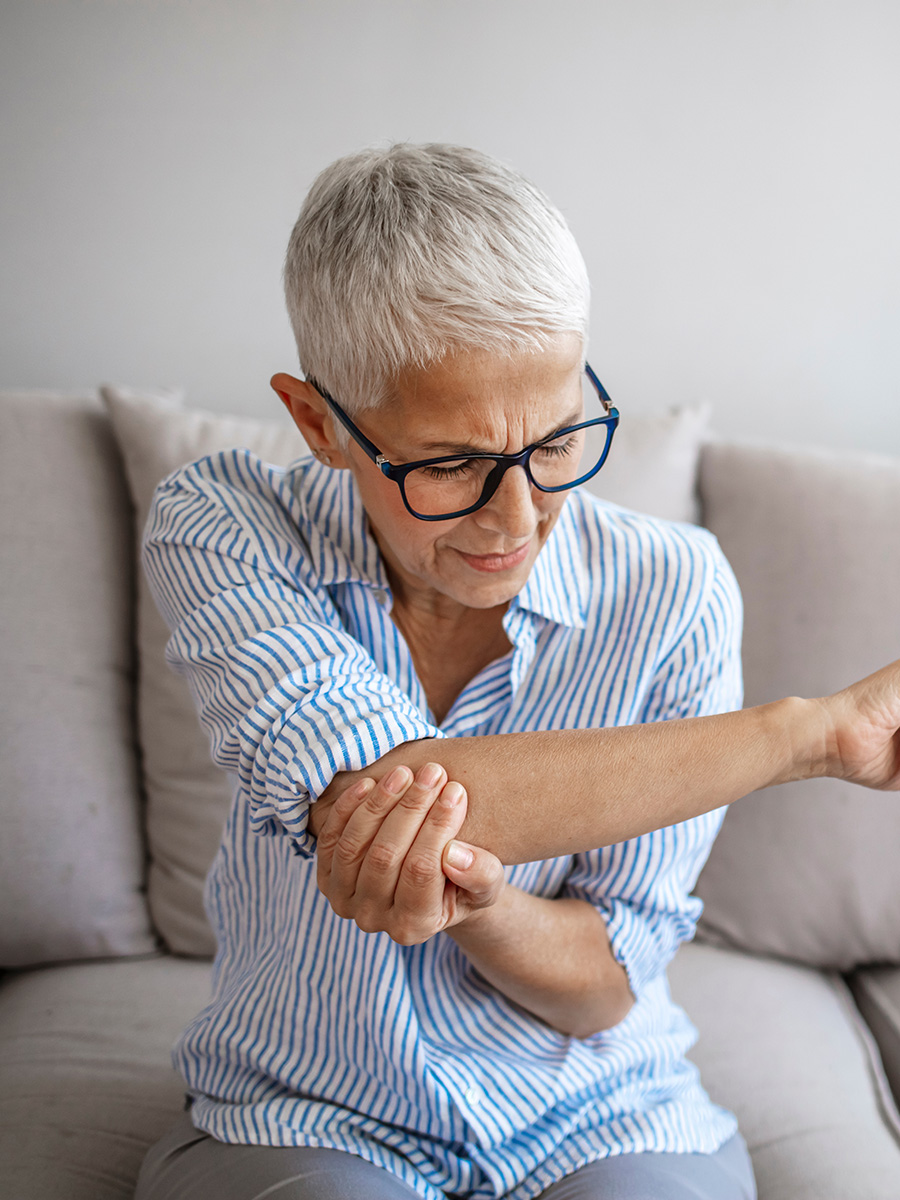 Mature woman holding here elbow in pain