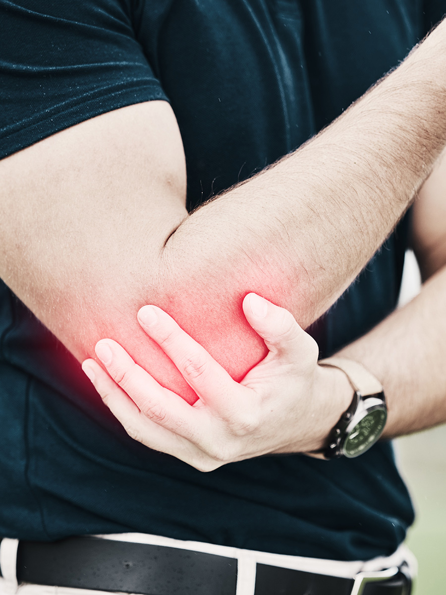 A golfer holding his elbow in pain