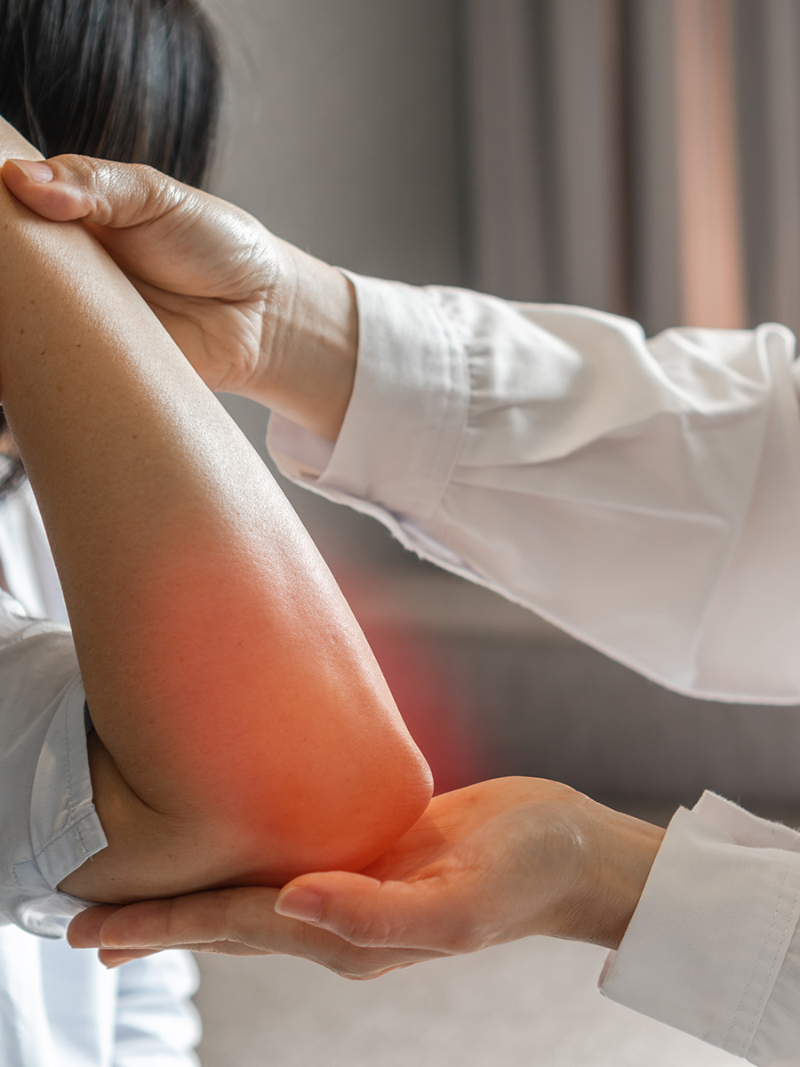 A woman getting her elbow inspected by a doctor