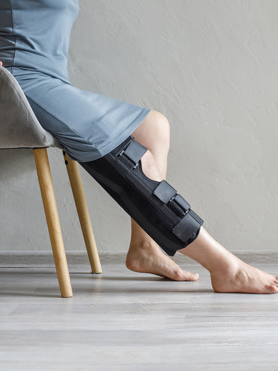 person with a knee brace sitting in a chair