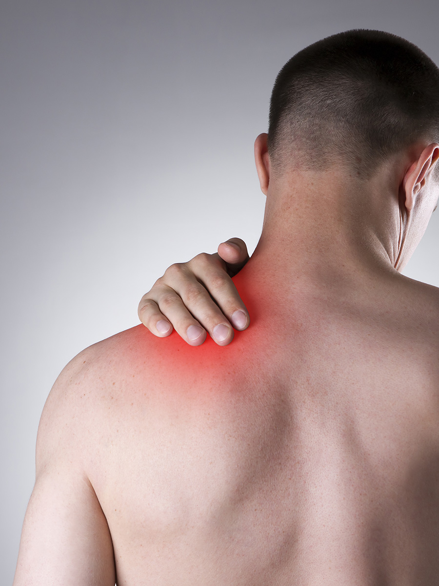 shirtless man rubbing his shoulder