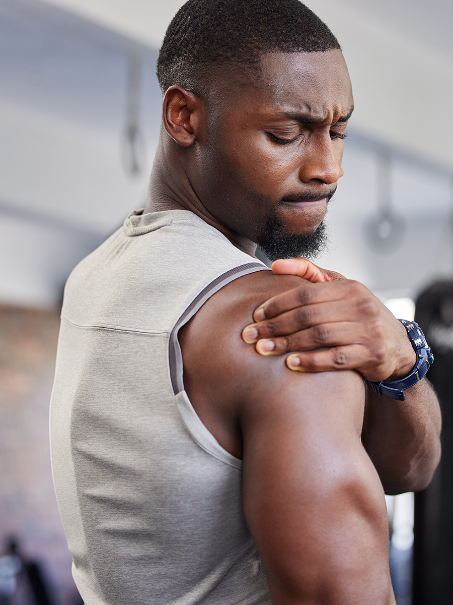 Fit man rubbing his shoulder