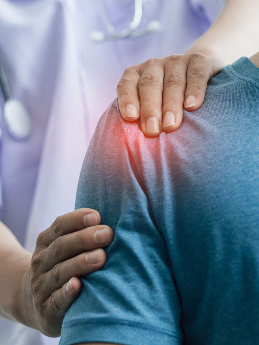 A man having his shoulder evaluated by a doctor