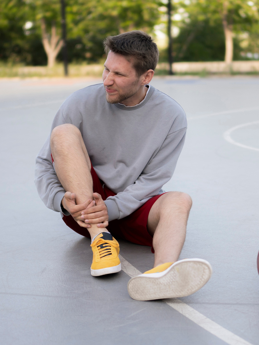 A man on the ground holding his ankle
