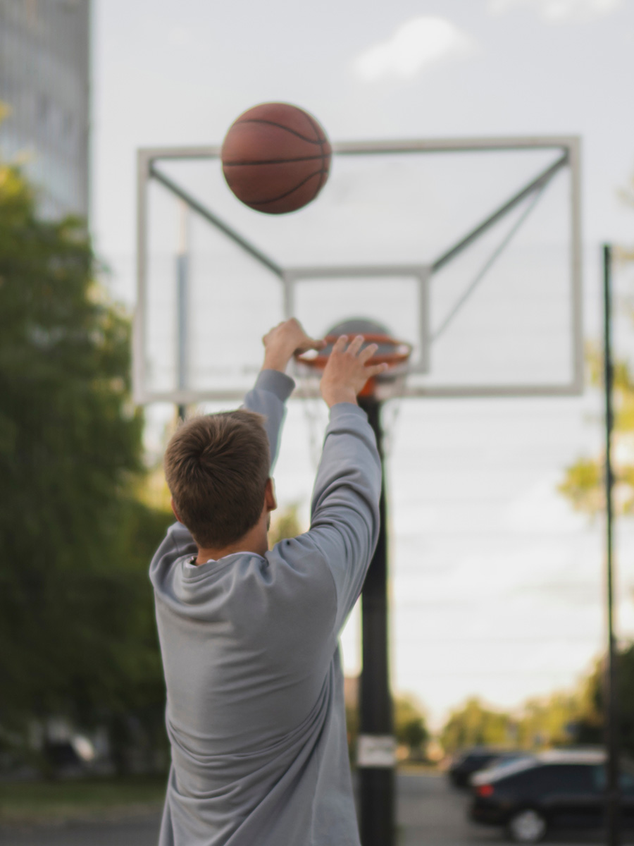 Man playing basketball outdoors