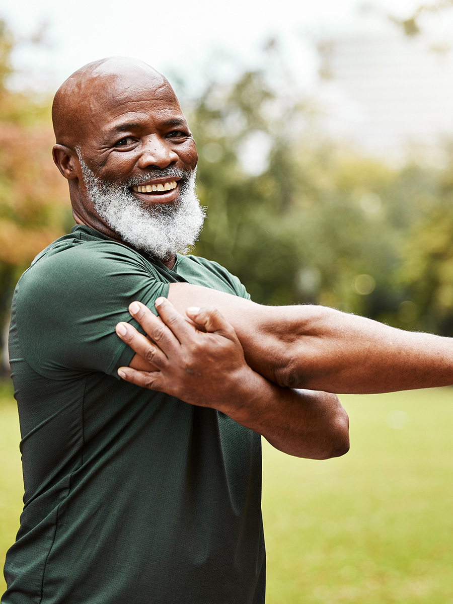 man in green stretching outdoors