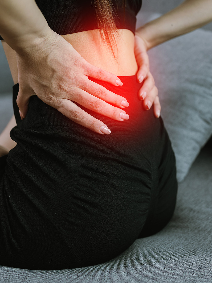 Fit woman holding her back in pain