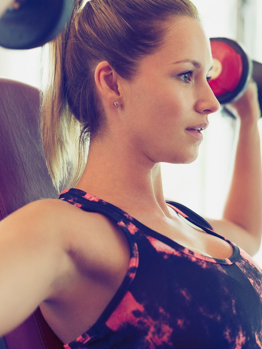 Woman doing shoulder presses with dumbbells