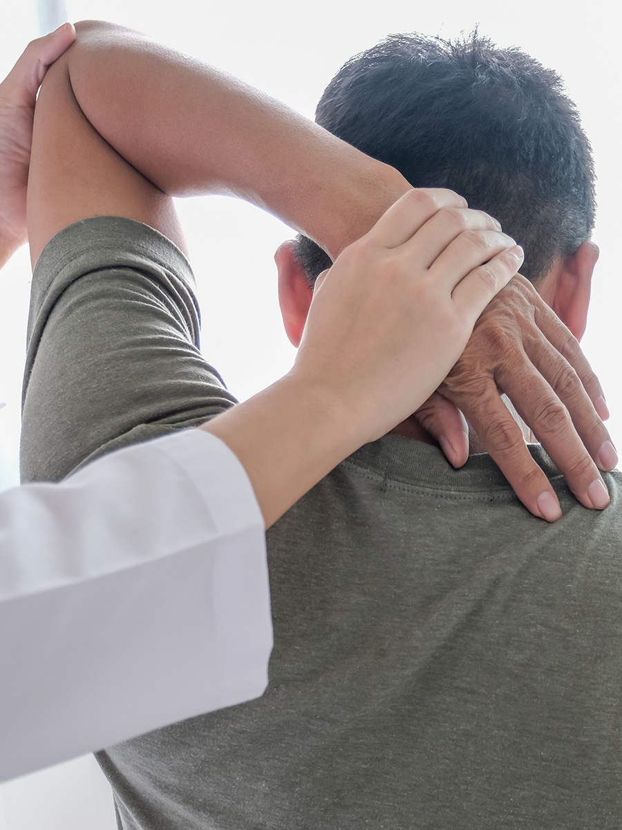 A man having his shoulder examined by a doctor