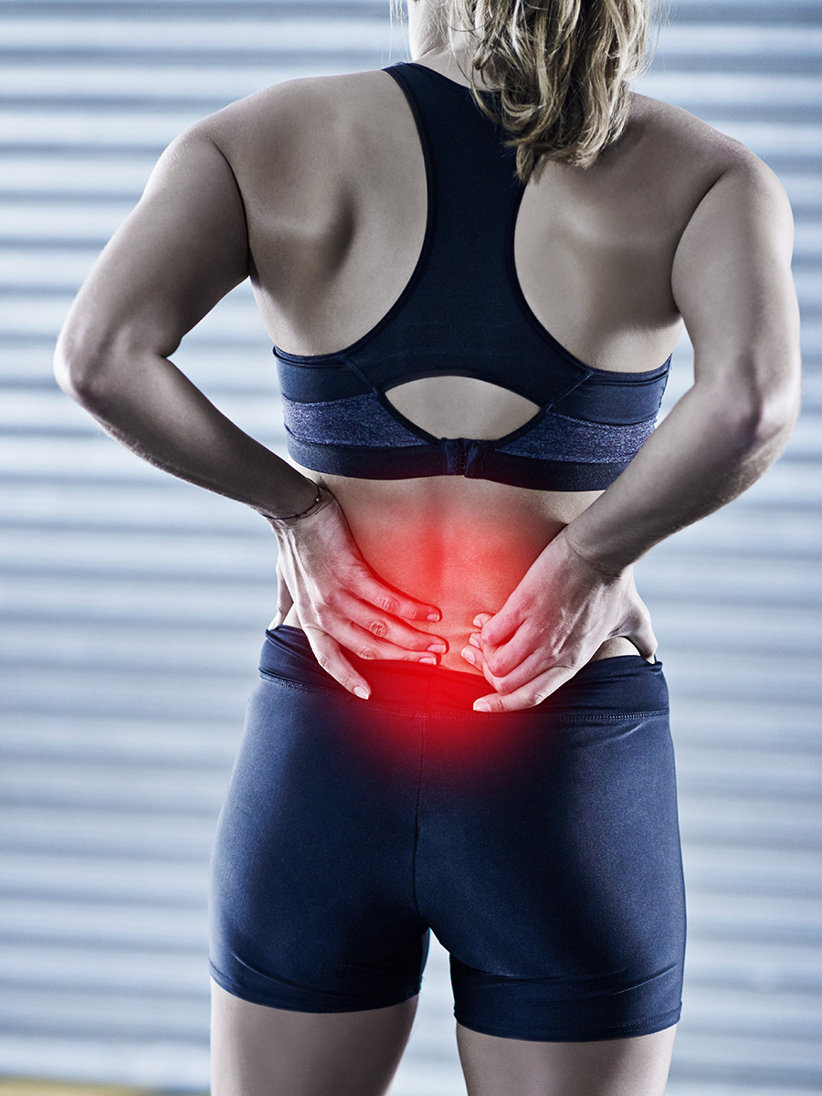 A woman holding her lower back in pain