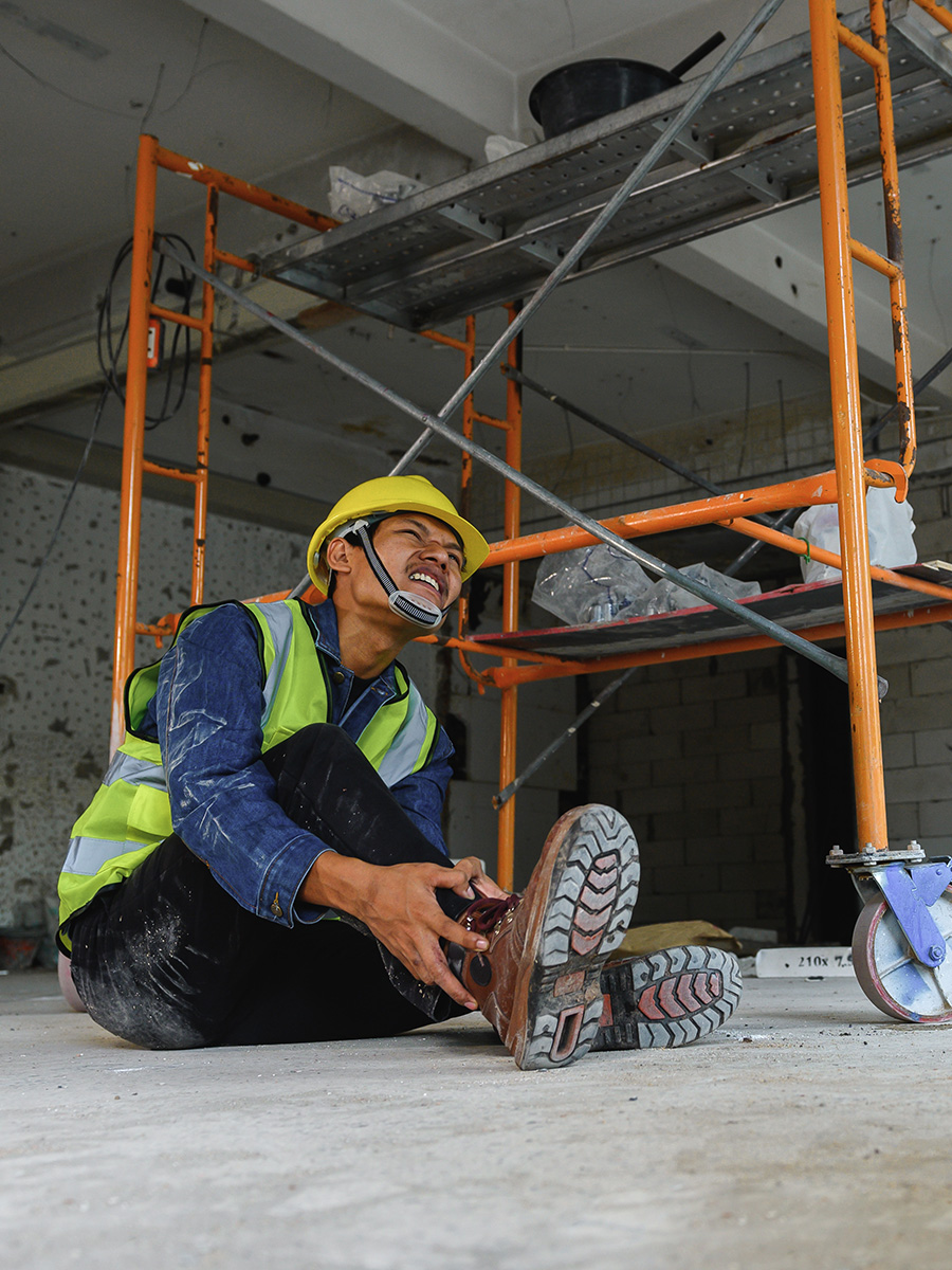 A worker holding his ankle in pain